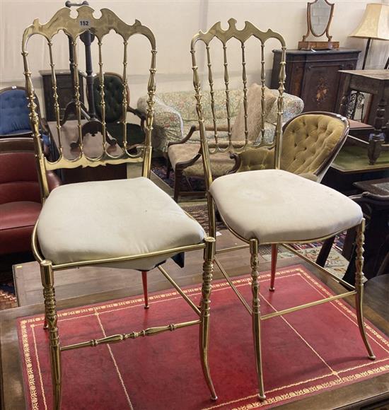 A pair of brass side chairs with padded seats